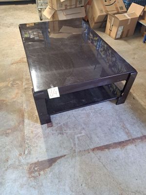 une table basse avec un plateau en verre, posée à même le sol