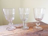 trois verres à vin vides posés sur une table en bois