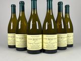 six bouteilles de vin blanc sont alignées