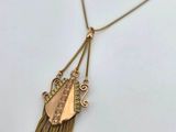 a gold plated necklace with fringes and a pendant with a leaf