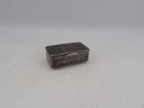 an old silver box sitting on top of a white surface