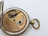 a close up of a pocket watch on a white surface