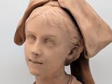 a statue of a woman with a hat on her head