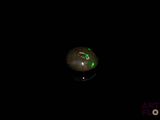 an image of a black background with a green light in the middle of it