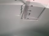 someone is measuring the height of a toilet bowl with a ruler