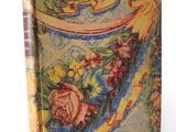 a close up of a book on a white surface with flowers
