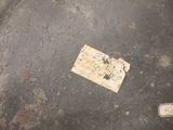 a stamp that is on the ground next to a piece of paper