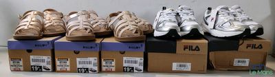 Plusieurs paires de chaussures sont empilées sur des cartons posés sur une table