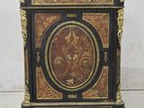 a black and gold cabinet with a painting on it
