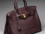a brown leather handbag with a gold lock on the handle