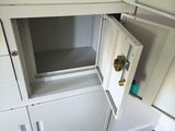 a small cabinet with a door open in the corner of a room