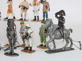 many figurines of soldiers on display on a white surface