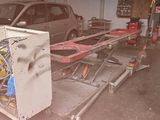 a car in the garage being worked on by a mechanic
