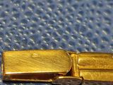 a gold buckle that is on a blue surface