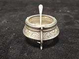 a small silver bowl with a spoon sticking out of it