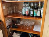 a wooden shelf with wine glasses and other items on it