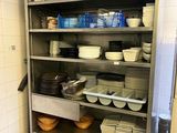 de nombreux plats et bols sur les étagères de la cuisine