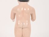 a small doll that is standing on a white surface