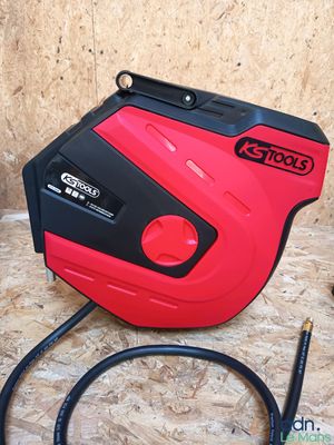 an image of a red and black air compressor on a wooden floor