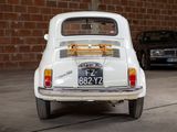 a small white car parked in front of a brick wall