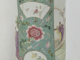 a green vase with a floral design on it