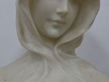 a statue of a woman with a hood and a flower on her head