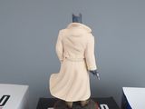 figurine of a man in a trench coat on top of a box