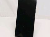 the back of a black cell phone sitting on top of a white table