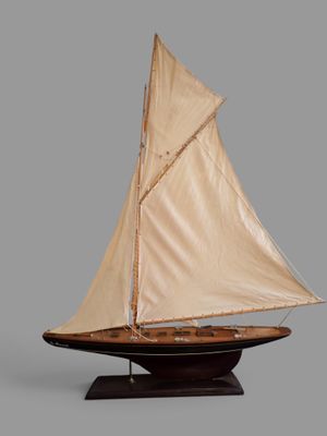 a model of a sailboat on a wooden stand