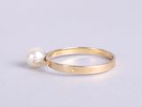 a close up of a gold ring with a pearl on it