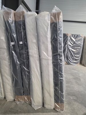 de nombreux rouleaux de matelas emballés dans du plastique dans un entrepôt