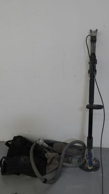 a bag and a vacuum on the floor next to a wall