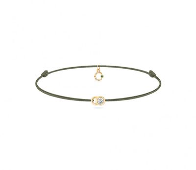 un bracelet en or orné d'un diamant et d'un cordon noir