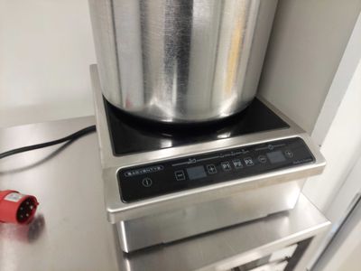 une casserole en argent posée sur une cuisinière en argent