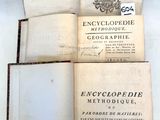 trois livres ouverts posés les uns sur les autres sur une table