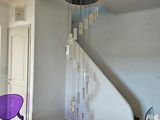 une chaise violette dans un coin d'une pièce où un lustre est suspendu au plafond