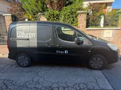 the van is parked on the side of the road in front of a house