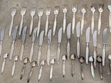 many forks and spoons laid out on a table