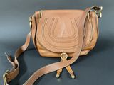 a close up of a brown purse on a black surface
