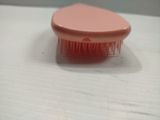 a pink brush that is sitting on a table