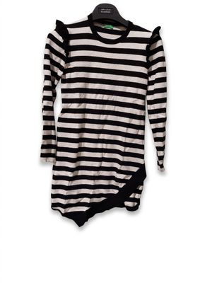 une chemise à rayures noires et blanches suspendue à un cintre sur un mur blanc