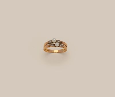 a close up of a ring with two pearls on it