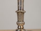 a silver candle that is on a wooden table