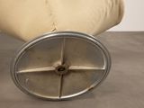 an image of a chair that has a metal wheel on top of it