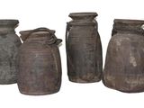 trois vases marron sont alignés sur une surface blanche