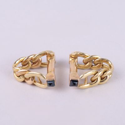 une paire de boucles d'oreilles manchette dorées ornées de pierres noires