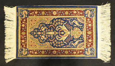 a close up of a rug on a black surface with fringes