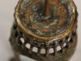 a small metal candle holder on a white surface