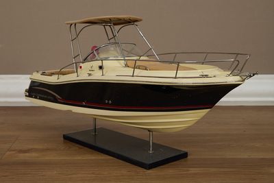 une maquette de bateau posée sur un socle au sol