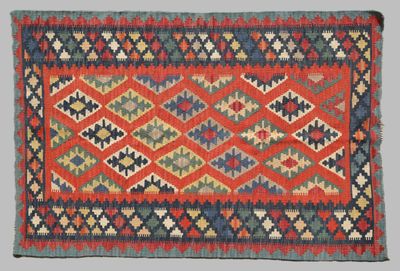 un tapis rouge, bleu et vert orné d'un motif en losanges
